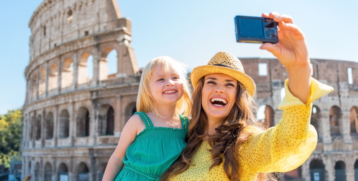 a women and child pose in front of the Colosseum in Rome.