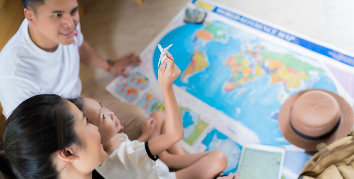Family planning a vacation in front of a map, picture