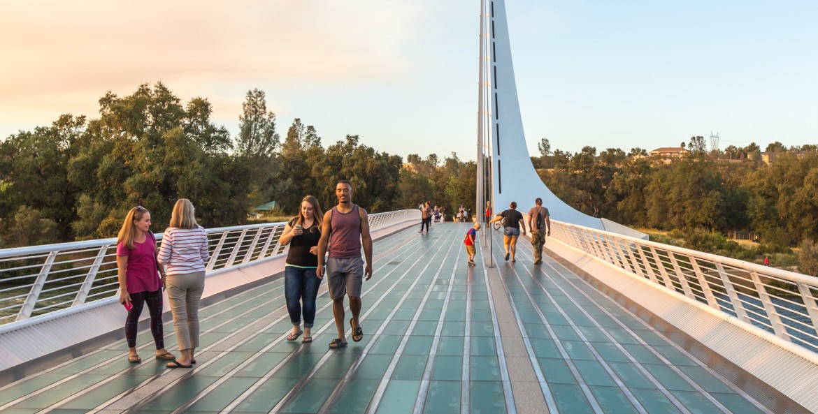 People stroll across the Sundial Bridge at sunset in Redding, California, picture