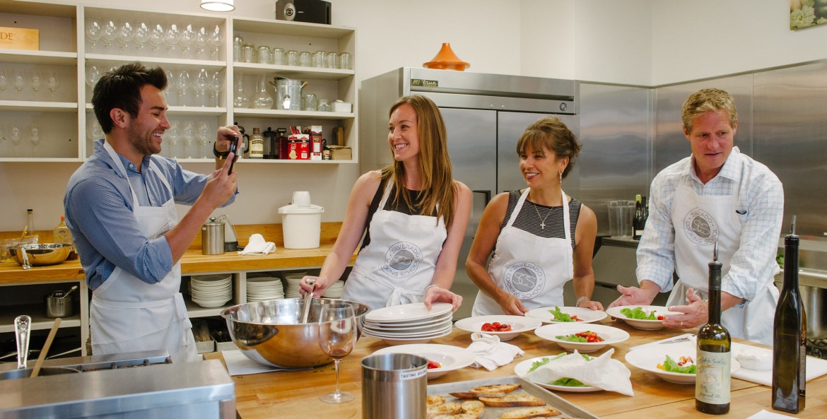 picture of students laughing and taking a picture while participating in a cooking class