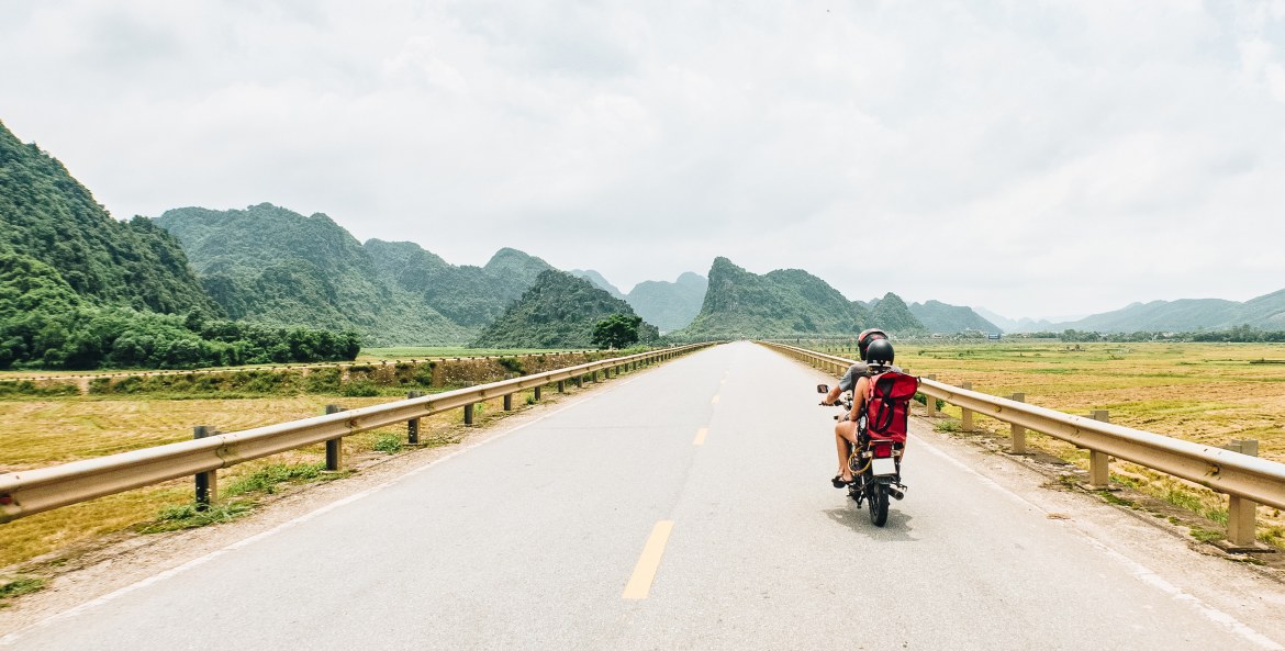 A backpacker couple rides through Vietnam on an antique motorcycle, image
