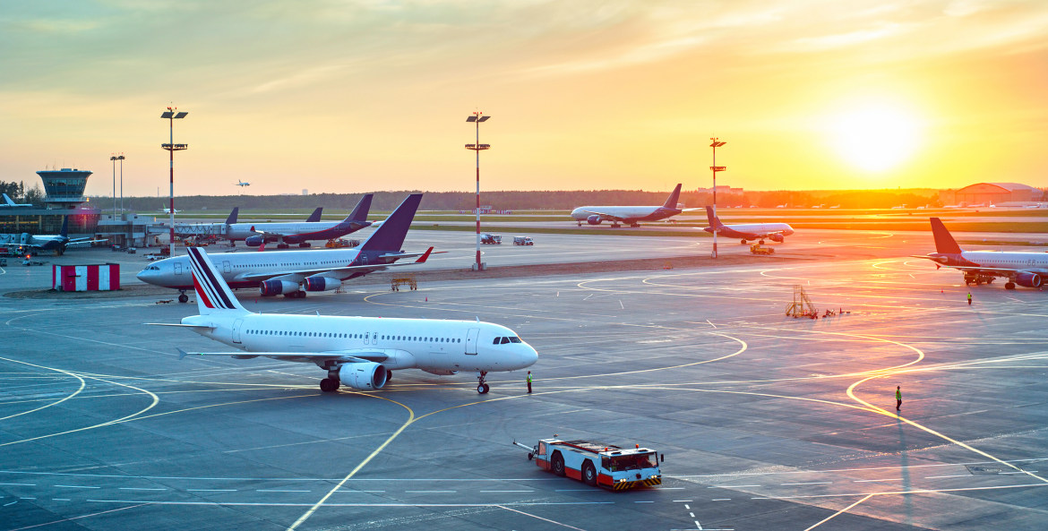 Planes on the airport tarmac at sunset, image
