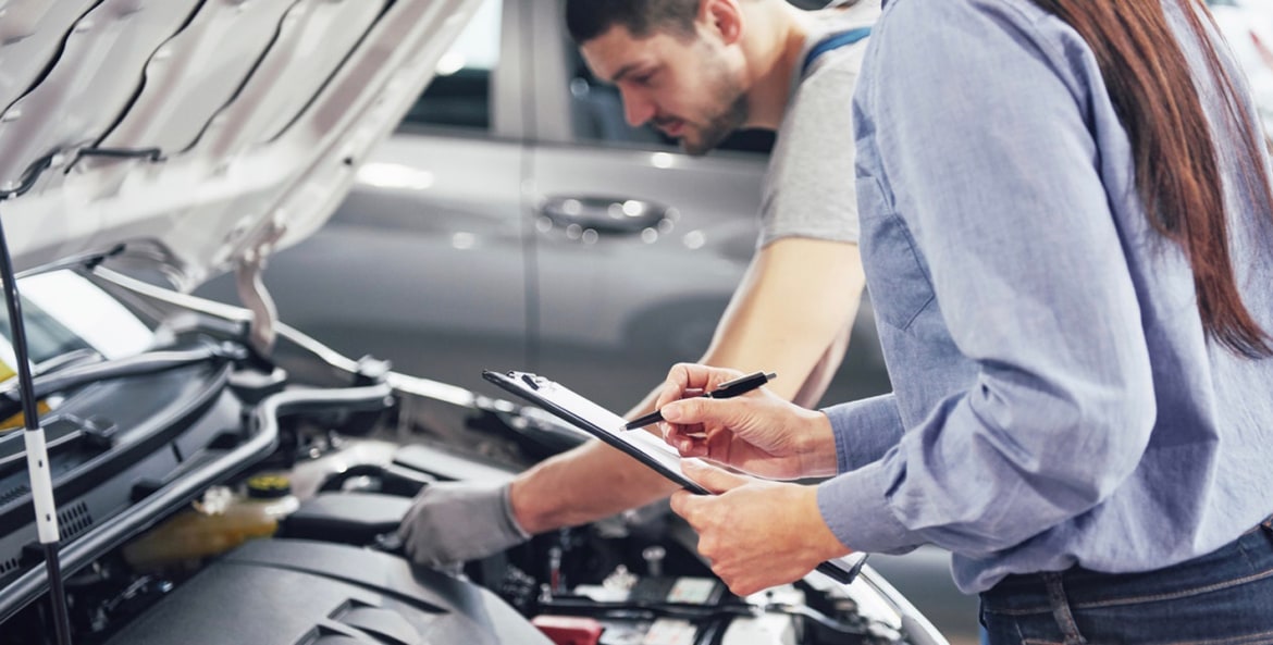 Mechanics perform a full inspection of a car engine.