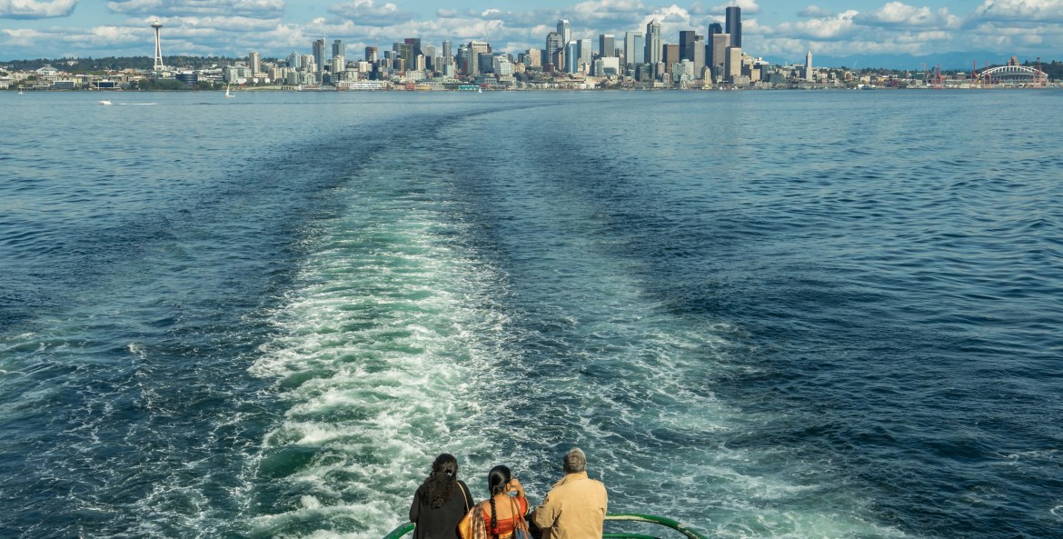 Bainbridge Island ferry passengers look out on the Seattle skyline views, picture