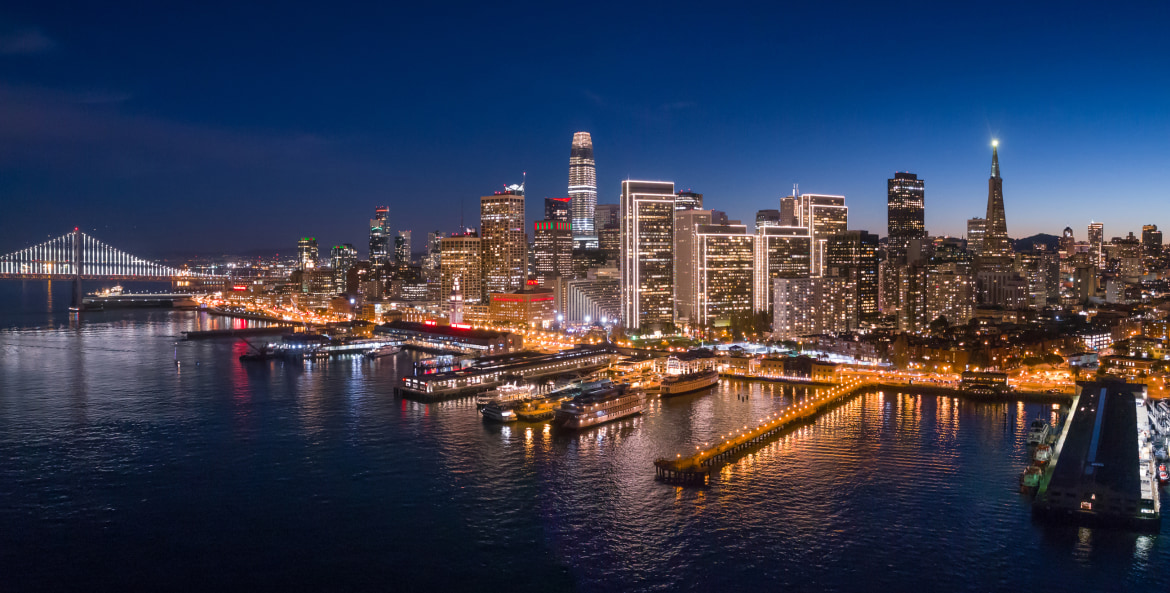 The San Francisco skyline and lights reflect off the San Francisco Bay at Dusk, image