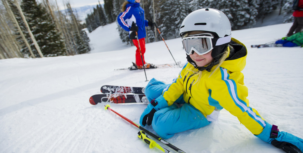 A child rests on a ski slope in Park City, Utah.