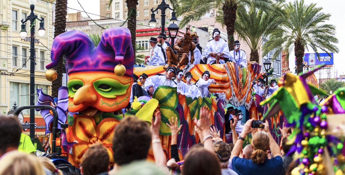 a float passes down a crowded street in New Orleans during the Mardi Gras parade, picture