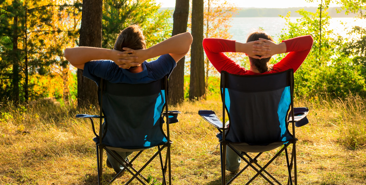 man and woman enjoy the view of a lake while camping, picture