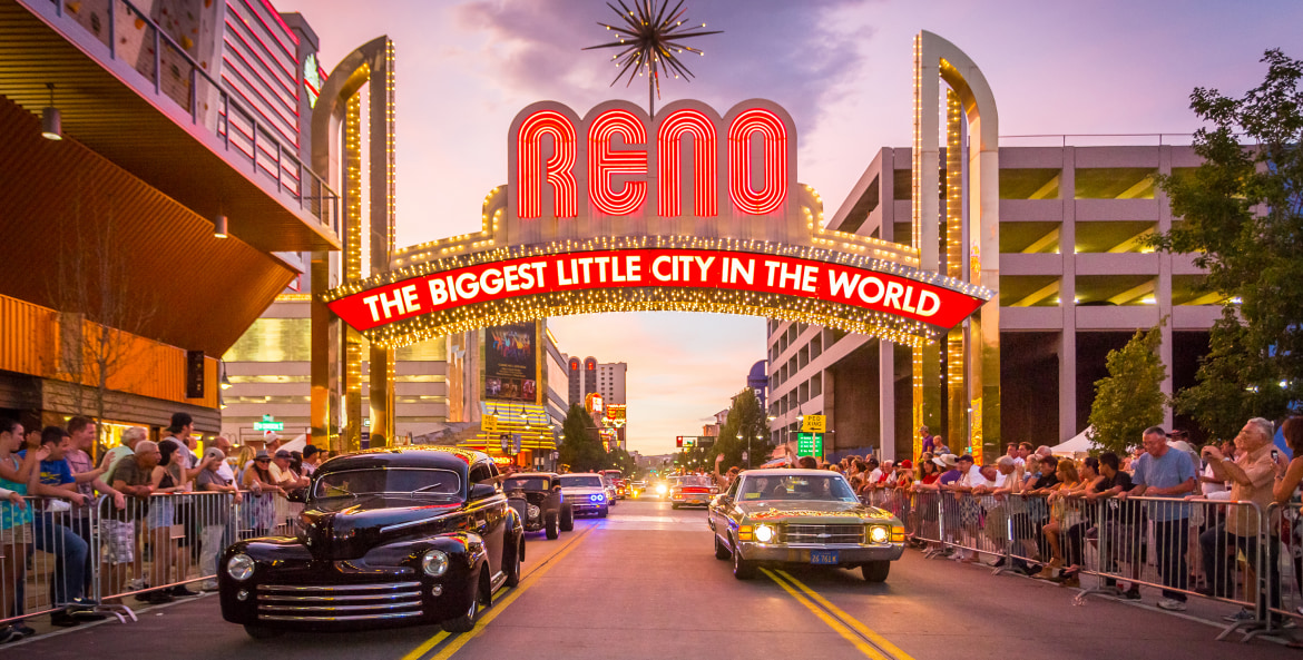 Classic cars drive beneath the famous "The Biggest Little City in the World" sign in Reno, Nevada, photo