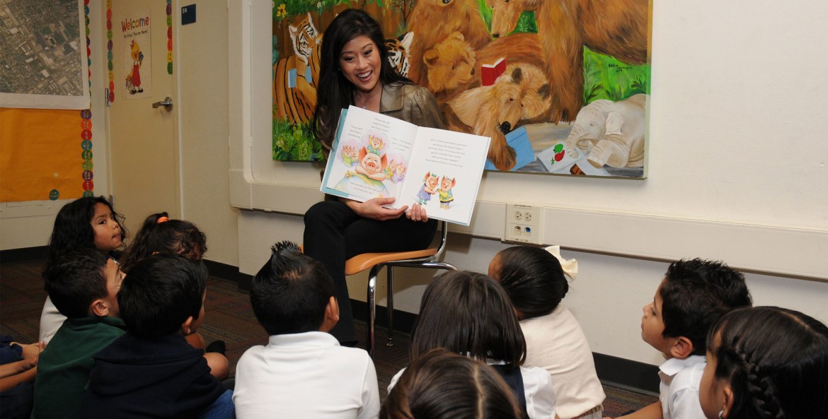 Kristi Yamaguchi reading her book, Dream Big, Little Pig!, to kids in a classroom, picture