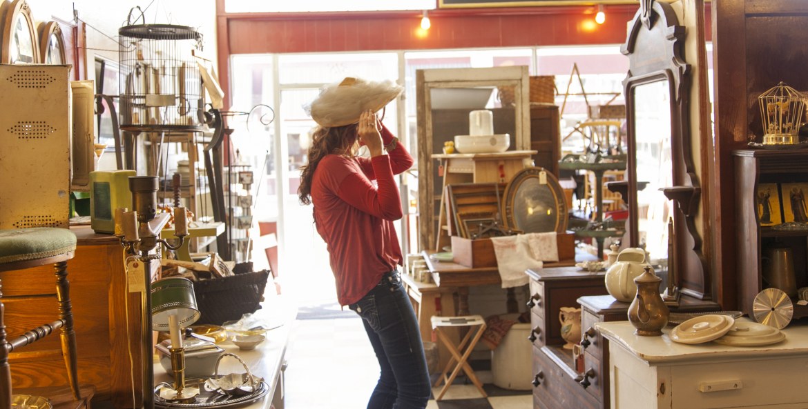 A woman tries on a hat in the Vain & Vintage store in Pocatello, Idaho, picture