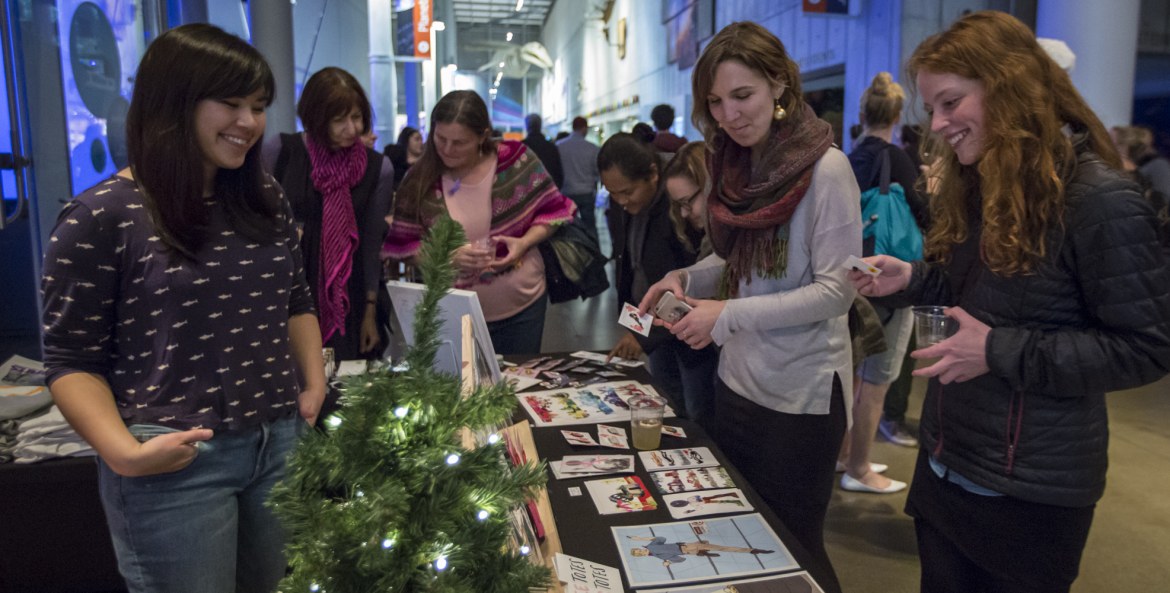 Guests at the California Academy of Science's NightLife Holiday Bazaar event look at a vendor's wares, photo