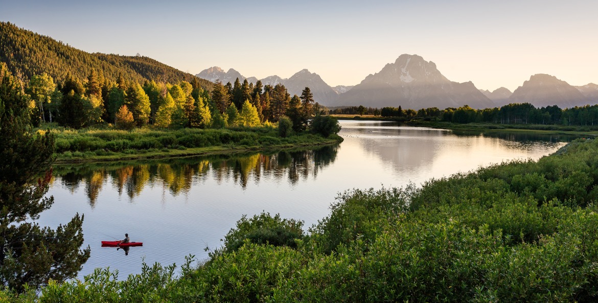 A fisherman on the quiet Snake River in Grand Teton National Park, image
