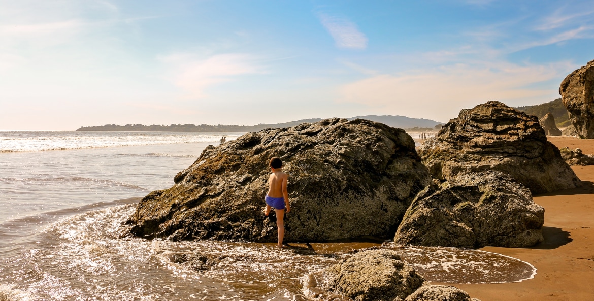 A child plays on the rocks at Stinson Beach in Marin County, California photo