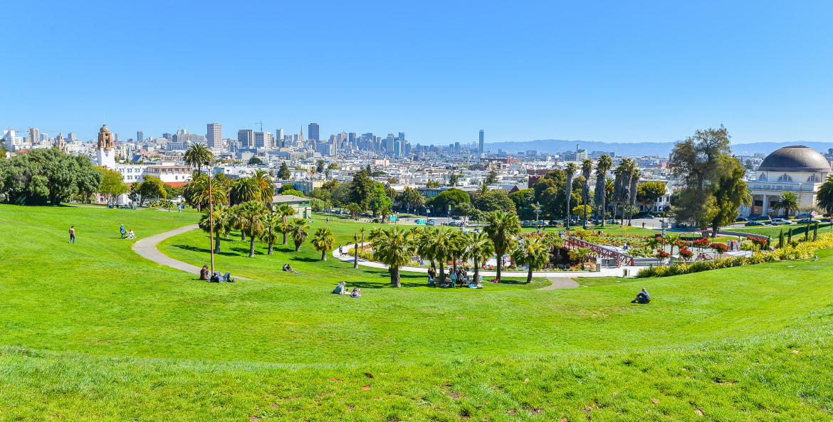 People relax in Mission Dolores Park on a sunny day, image