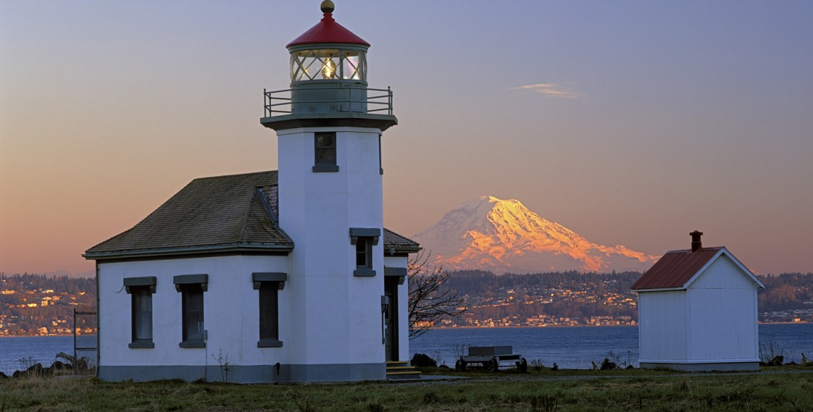 Mount Rainier rises on the Washington mainland in view of Point Robinson Lighthouse on Vashon Island