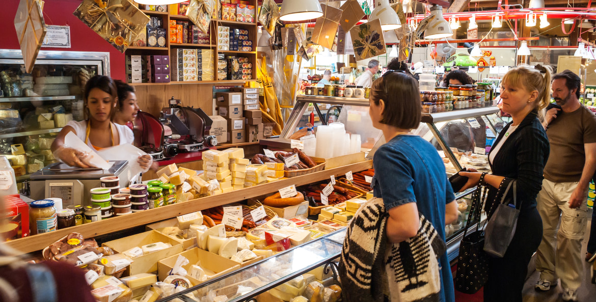 two women wait at the cheese counter in Granville Island's Public Market, image