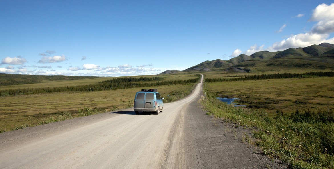 picture of a van driving along a stretch of the Dempster Highway above the Arctic Circle in northern Yukon.