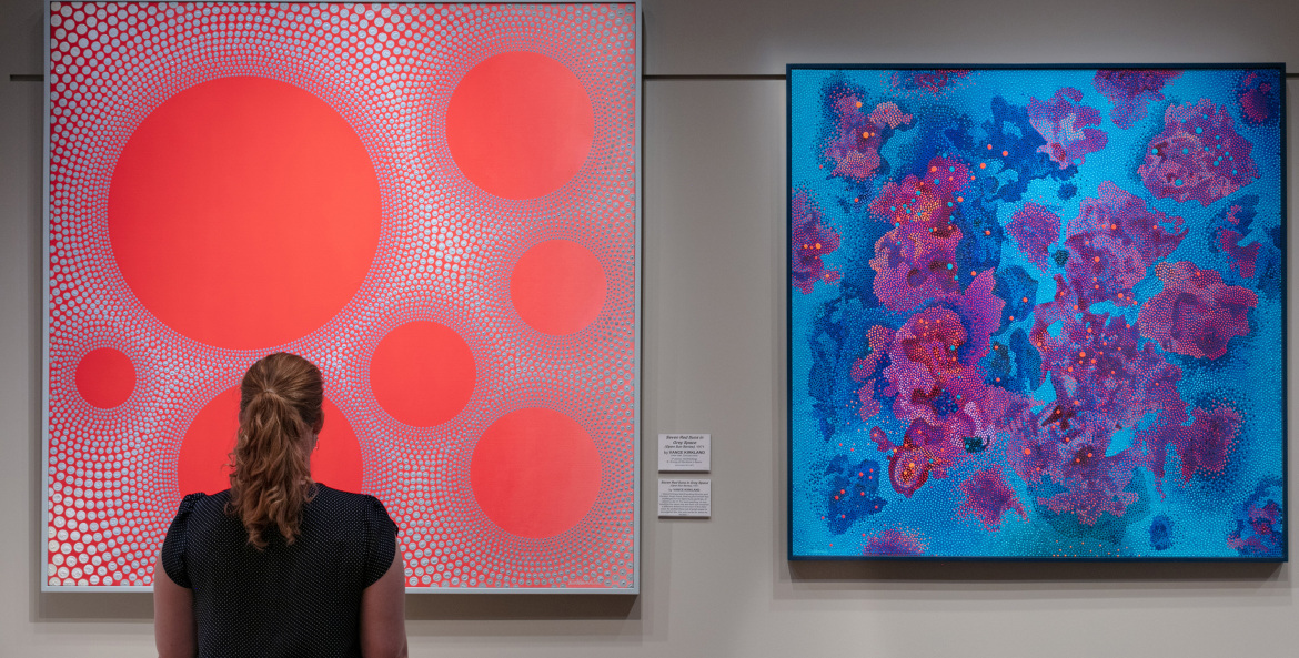 gallery visitor views two paintings by Vance Kirkland at the Kirkland Museum of Fine & Decorative Art in Denver, Colorado, picture