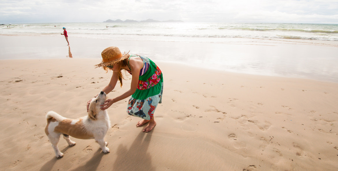 AAA Member on a beach vacation with her dog.