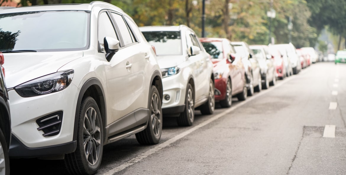 long line of cars parallel parked on a suburban street