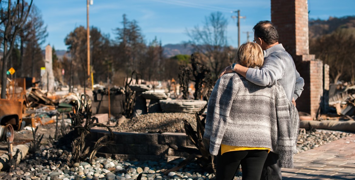 A couple embraces in front of a burned down home in Sonoma, California.