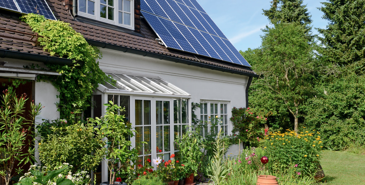 Older frame house with solar panels and garden