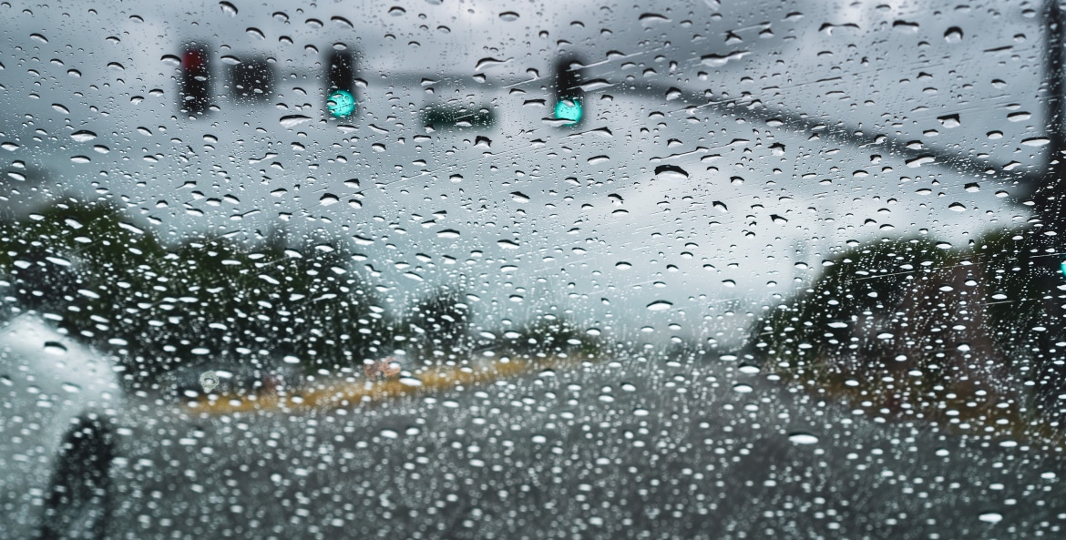 A car drives through the rain.