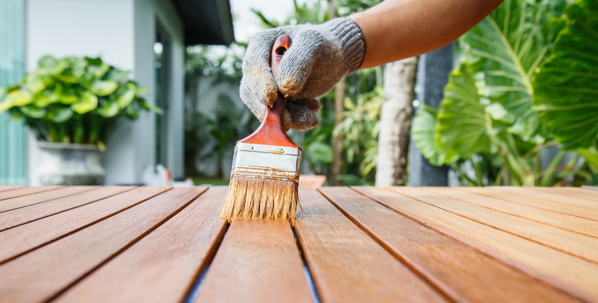 Homeowner staining a wood table