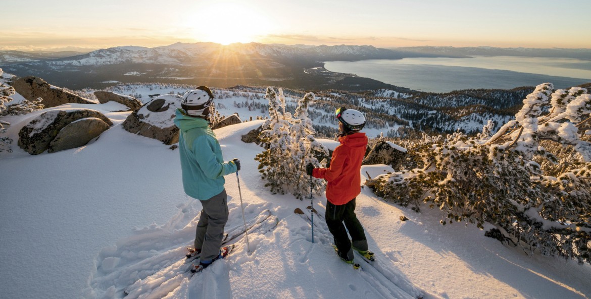 pair of skiers pause for a panoramic view of the winter scenery above Lake Tahoe, California