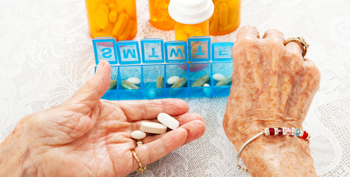 Close up view of elderly woman's hands as she sorts prescription medication