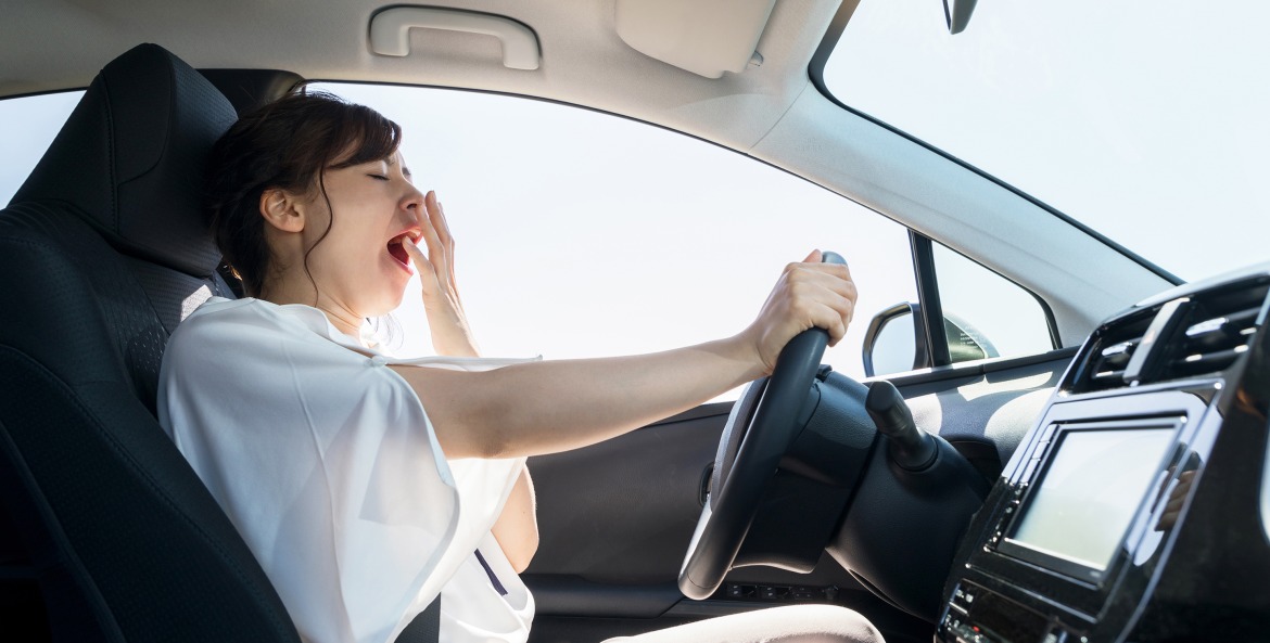 A woman yawns while driving.