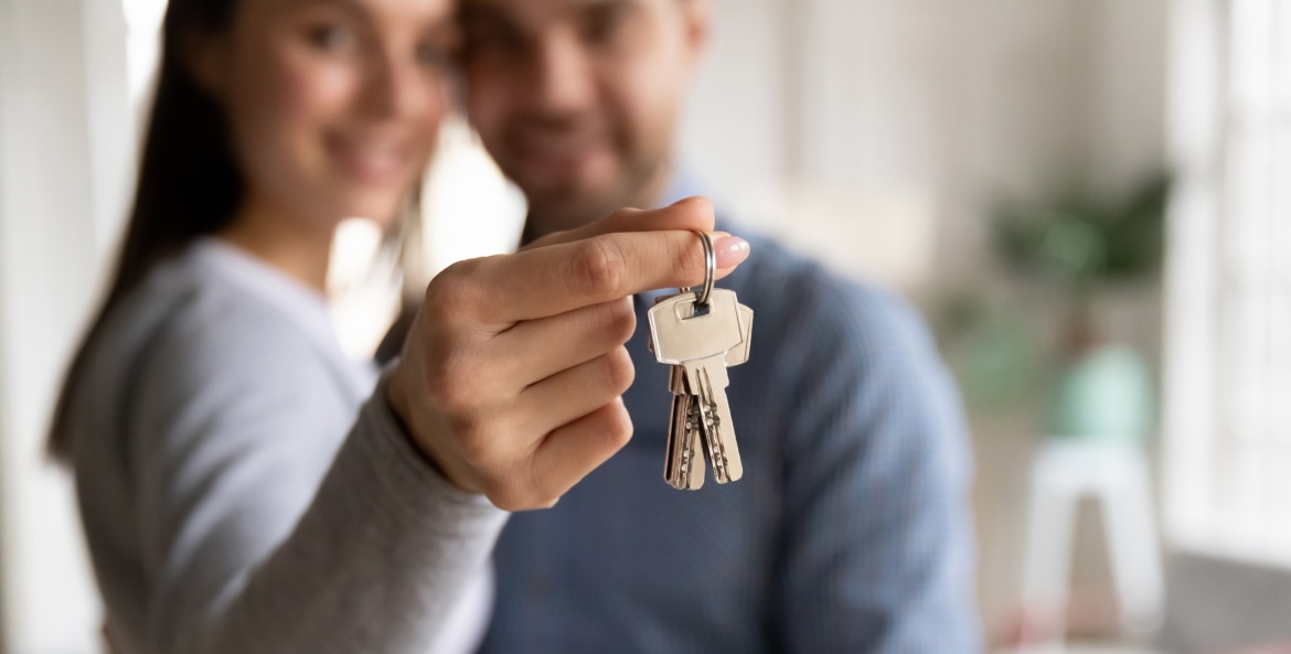 A couple holds the keys to their new home.