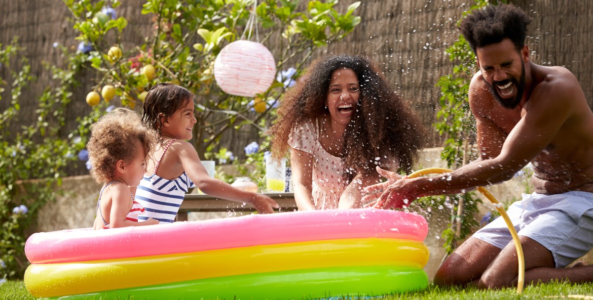 A family plays in a backyard inflatable pool.