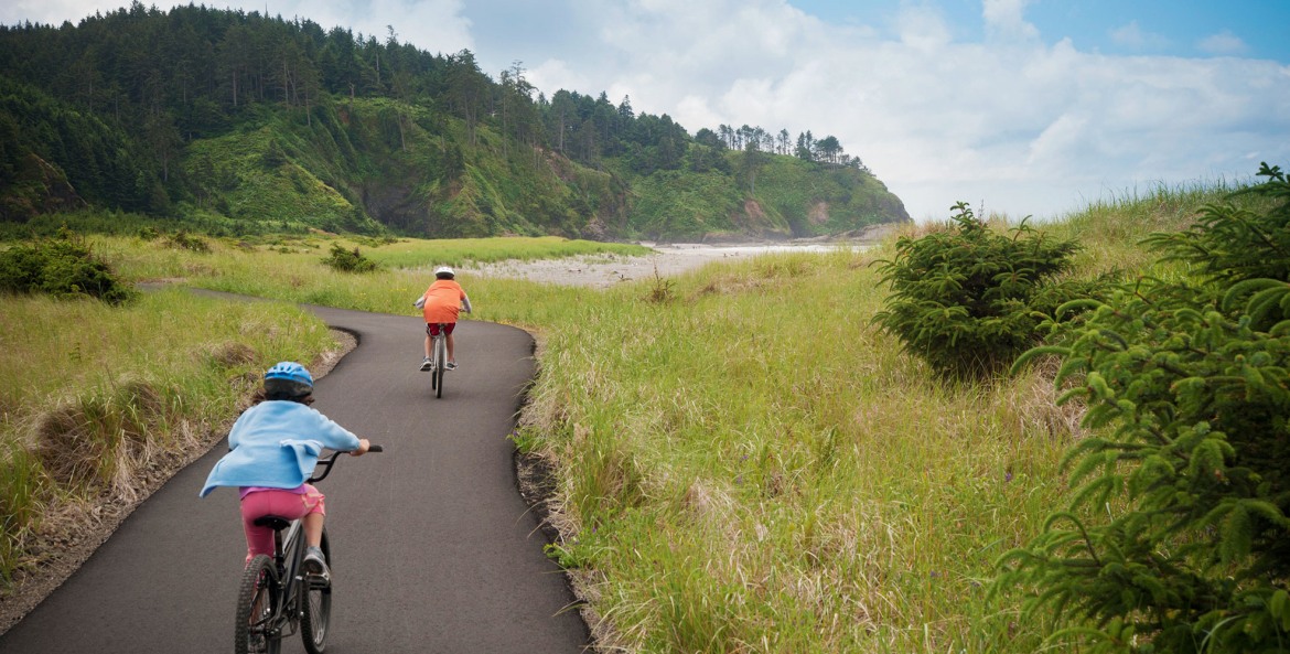 Kids ride their bikes on the paved Discovery Trail in Long Beach, Washington.