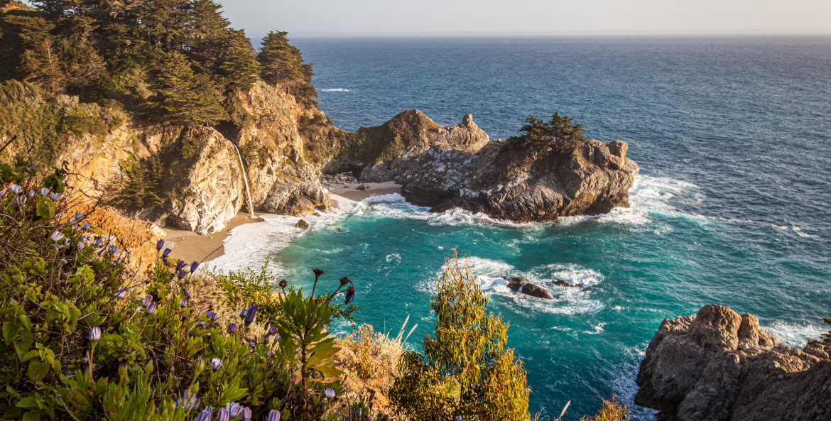 McWay Falls against a turquoise ocean on a sunny day.