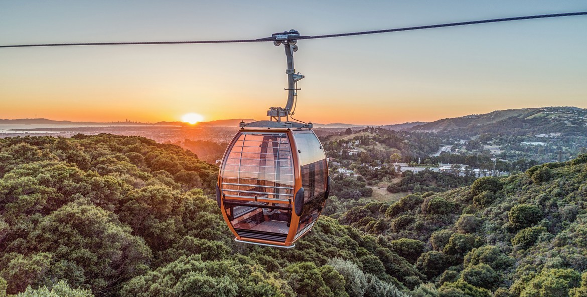 Oakland Zoo Gondola with the Oakland Hills and a sunset in the background.