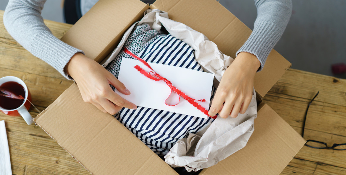 a woman packs a parcel to ship in the mail.
