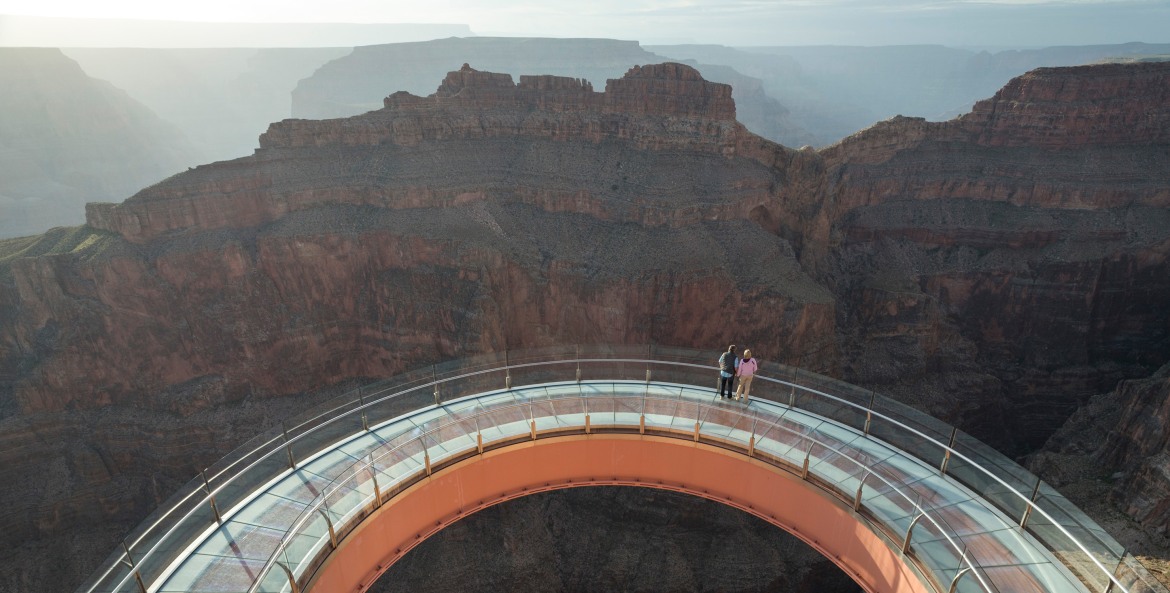 A couple stand at the center of the Grand Canyon Skywalk in Grand Canyon National Park.
