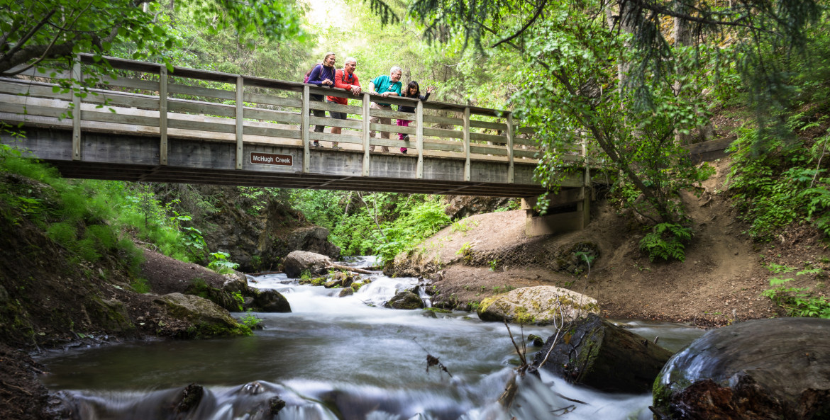 Hikers take in the views from McHugh Creek Bridge near Alaska's Turnagain Arm.