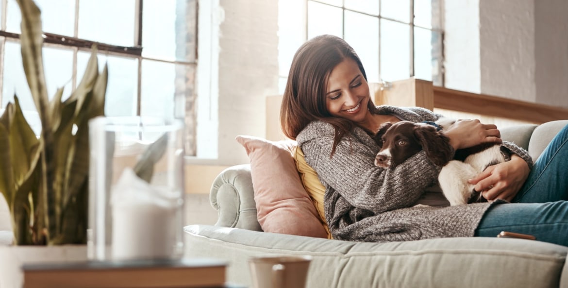 Woman lying on the couch with a dog