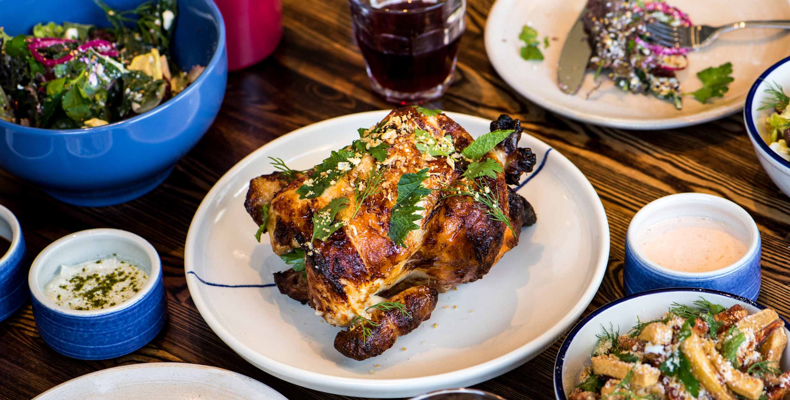 A full rotisserie chicken and sides on a table at RT Rotisserie in Hayes Valley, San Francisco