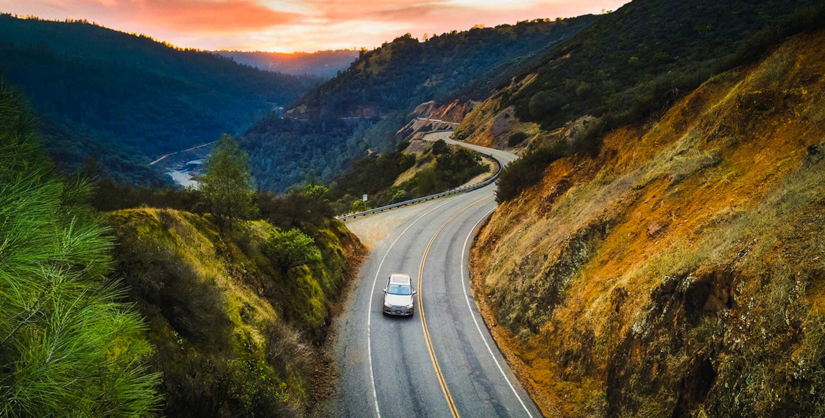 car viewed from overhead on curvy two-lane road at sunset, picture