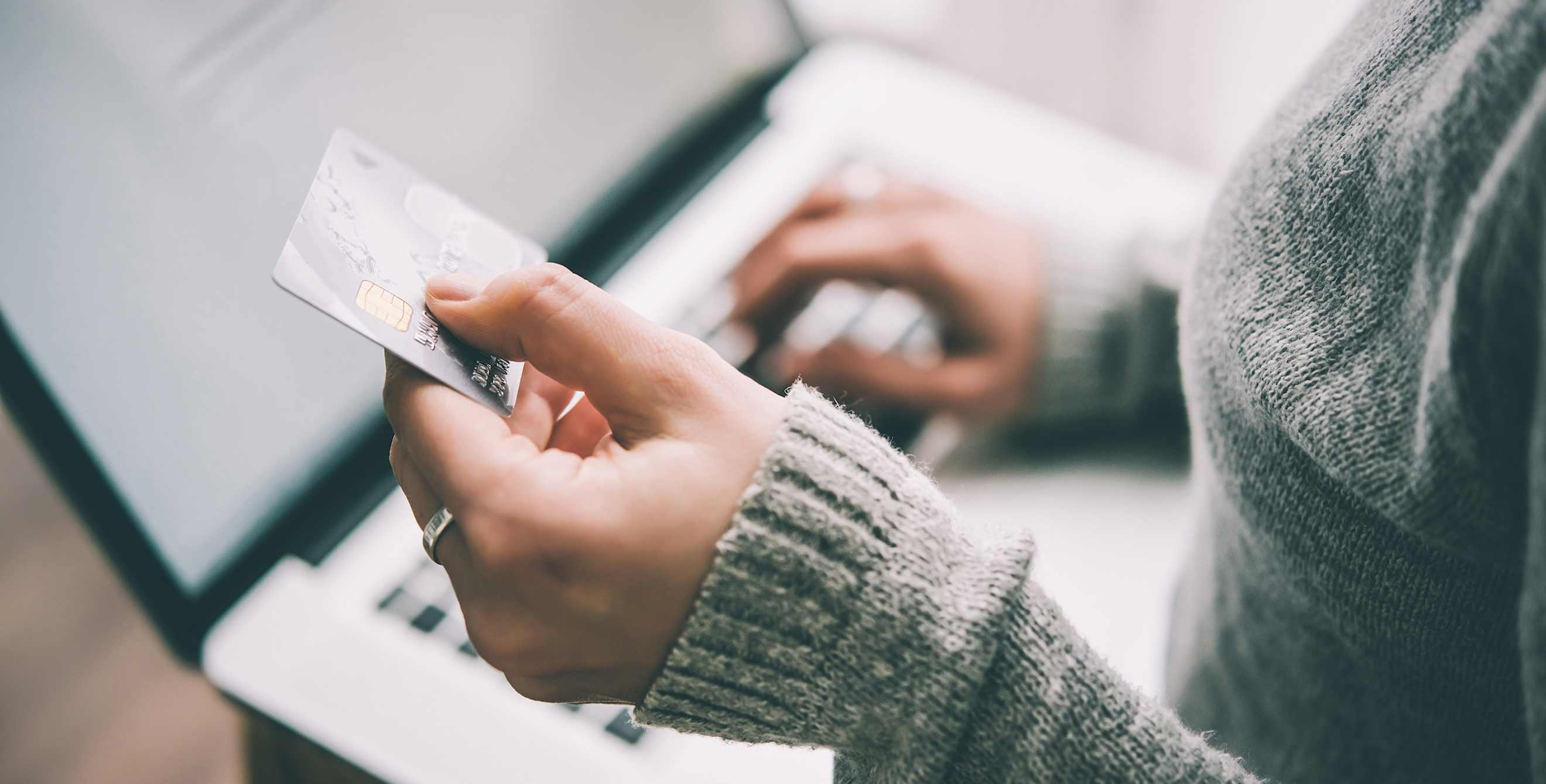 woman shopping online on laptop holding a credit card