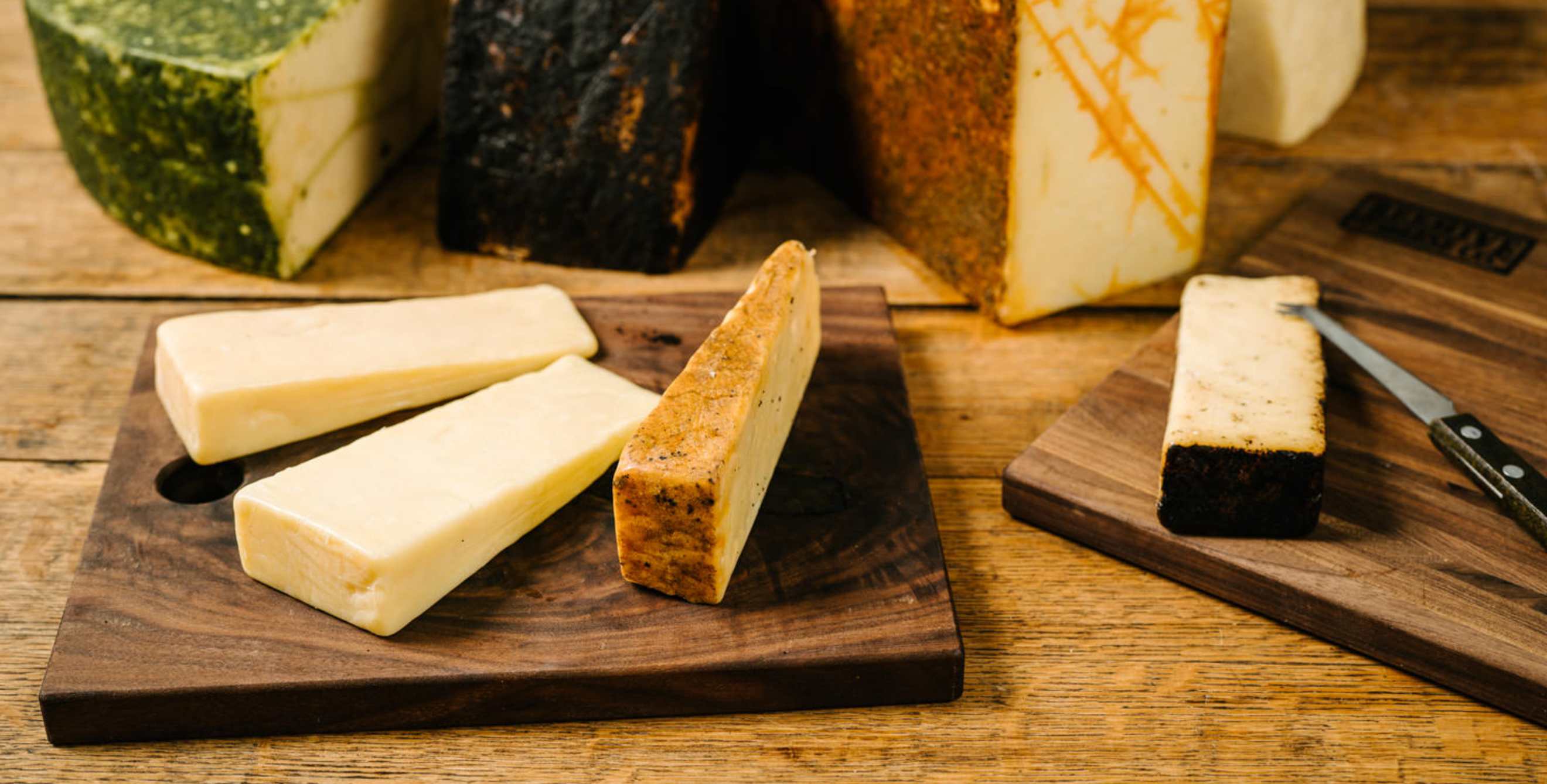 Cutting board displaying multiple cheese varieties, picture