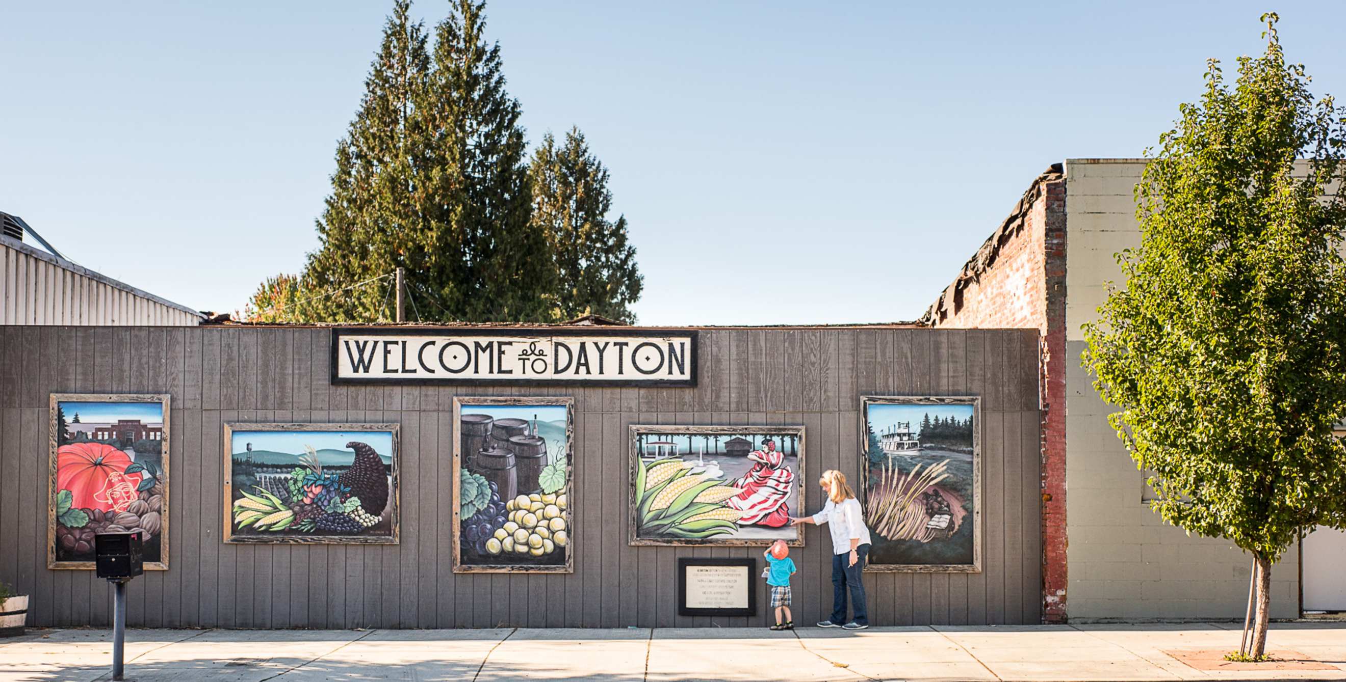 murals examined by woman and child along Ferry Street in Dayton, Oregon, picture