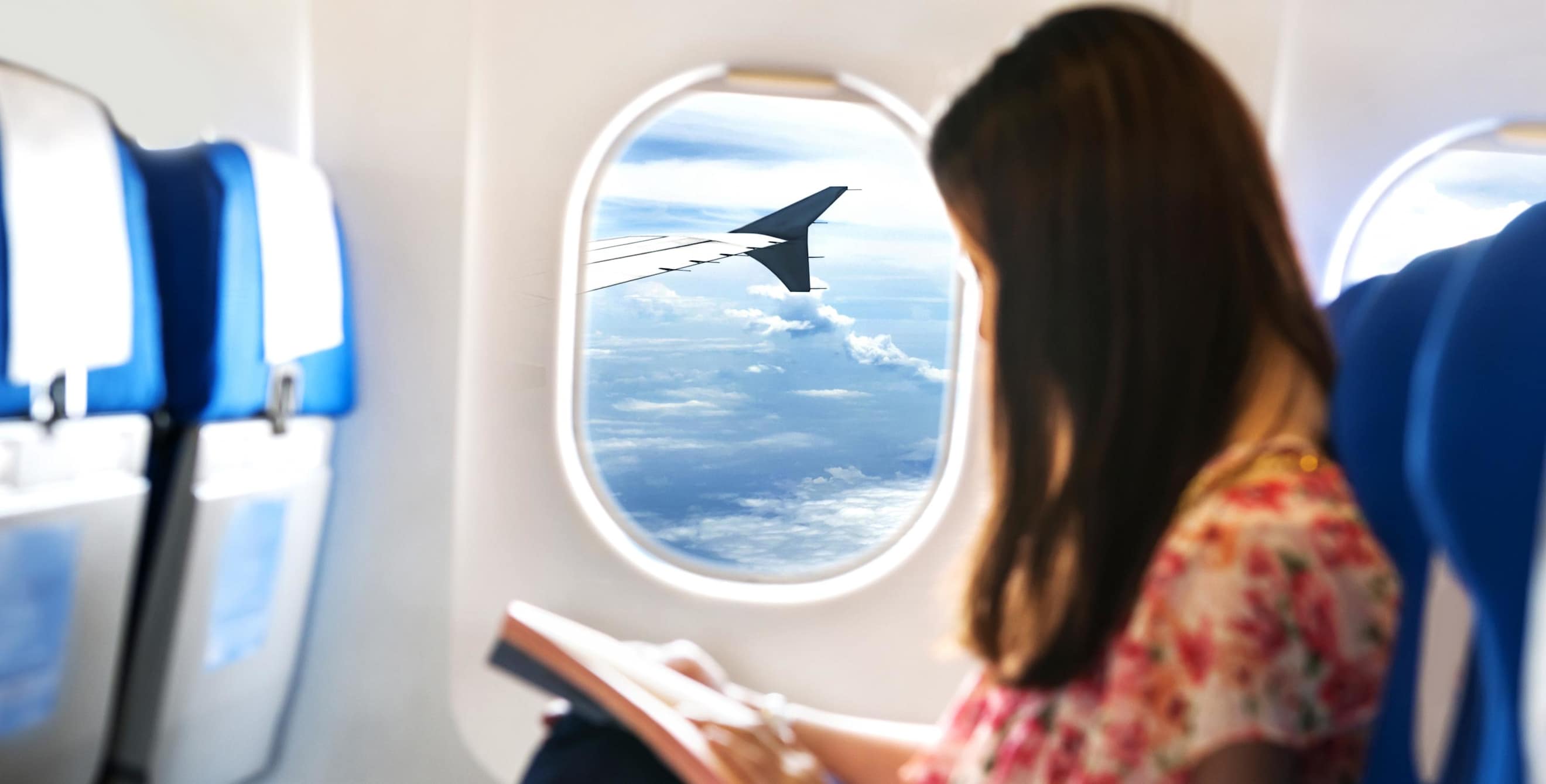 Relaxed airline passenger reads during a flight, image