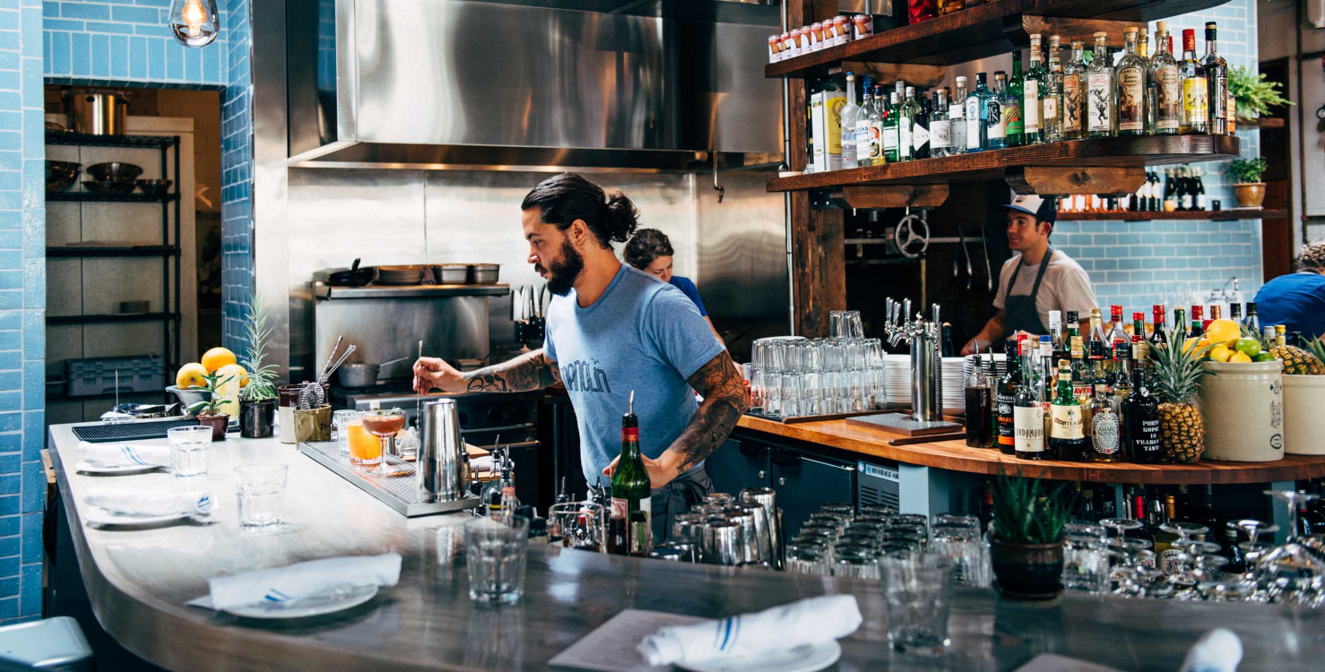 The bartender at Manolin in Seattle serves up Caribbean-inspired cocktails, image