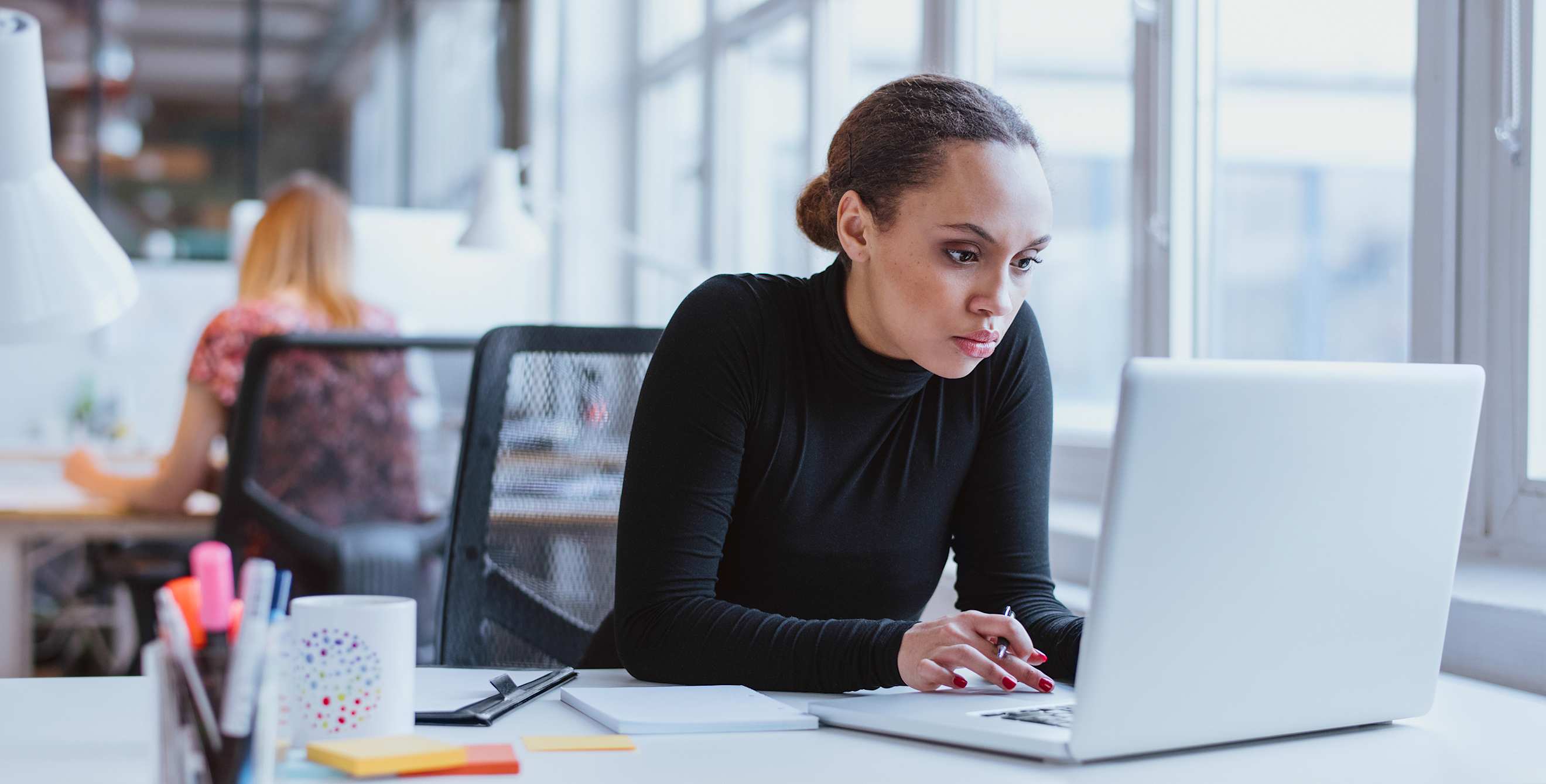 A woman works on a computer in a white office