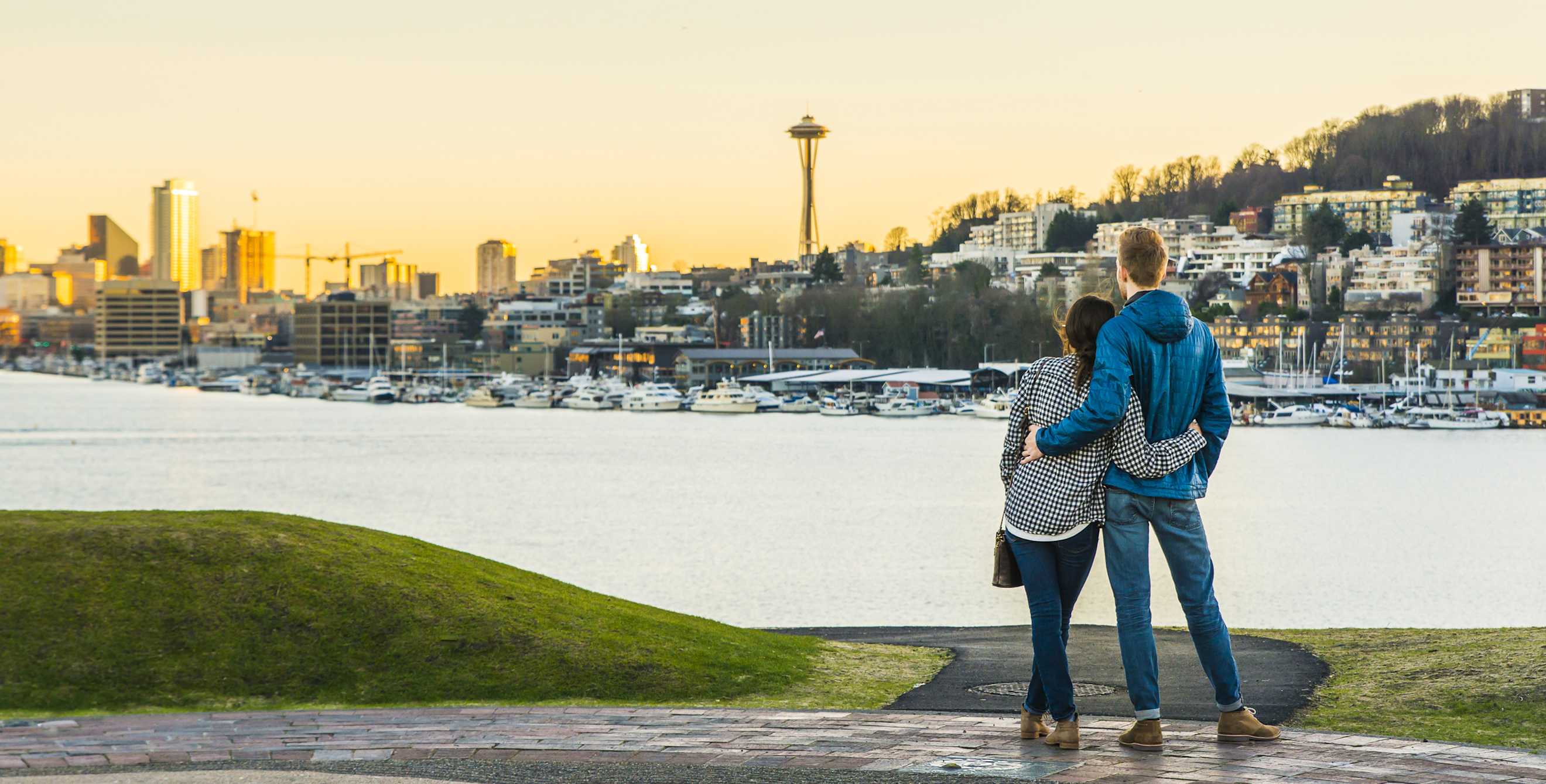 a couple looks out at the Seattle skyline, picture